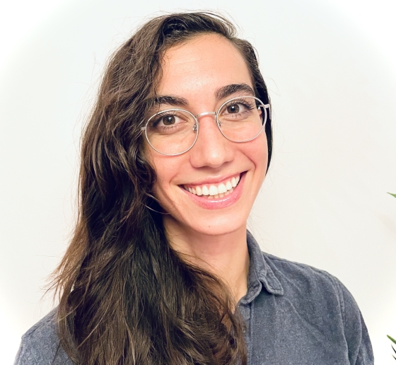 Young woman with wire rim glasses and long brown hair.